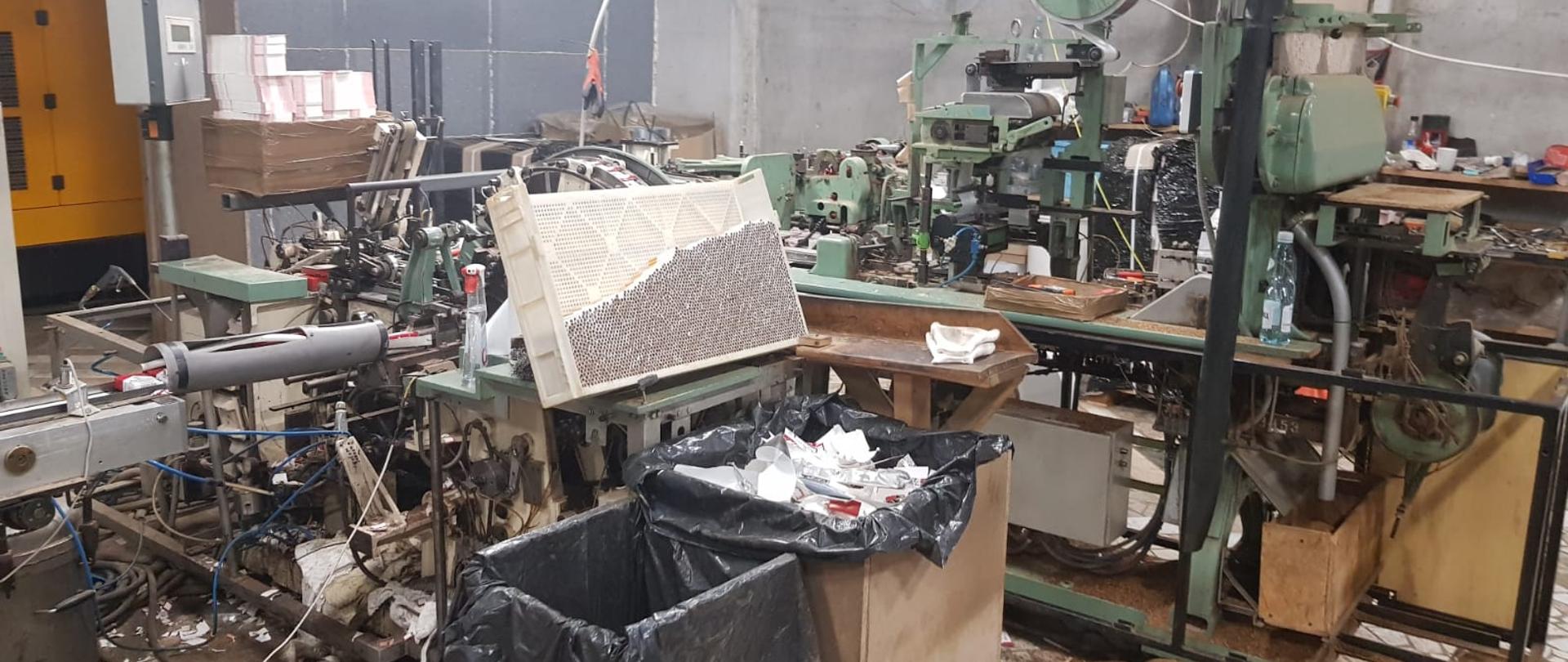 Maszyny do produkowania papierosów, widoczny pojemnik z papierosami.