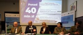 Zdjęcie ilustracyjne. Na zdjęciu za stołem prezydialnym siedzą dwie kobiety i trzech panów. od lewej: Zbigniew Sołtysiński, dyrektor Wielkopolskiego Parku Narodowego, Robert Gajda, zastępca prezesa zarządu NFOŚiGW, Paulina Hennig-Kloska, ministra klimatu
i środowiska, Olimpia Pabian, dyrektor Białowieskiego Parku Narodowego, Jan Reklewski, dyrektor Świętokrzyskiego Parku Narodowego.