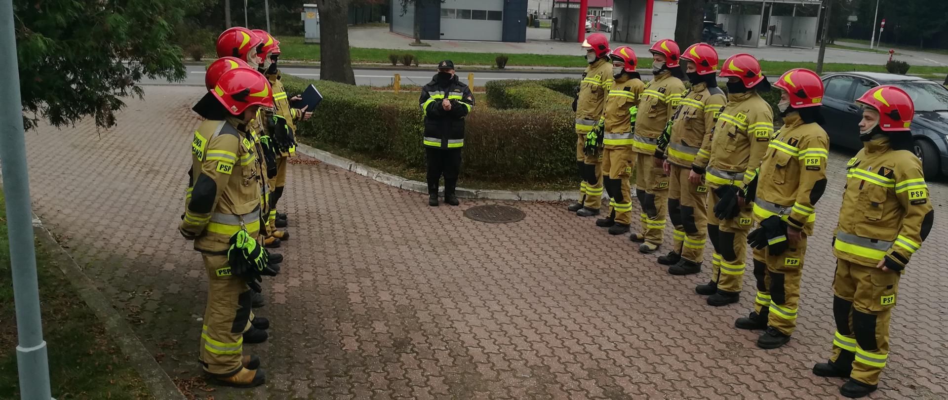 Zdjęcie przedstawiające zmianę służby przed budynkiem KP PSP w Gostyninie w dniu Święta Niepodległości