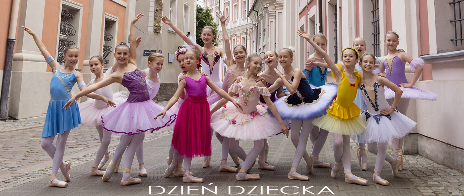 Uśmiechnięte dzieci w różnych pozach na ulicy starego miasta