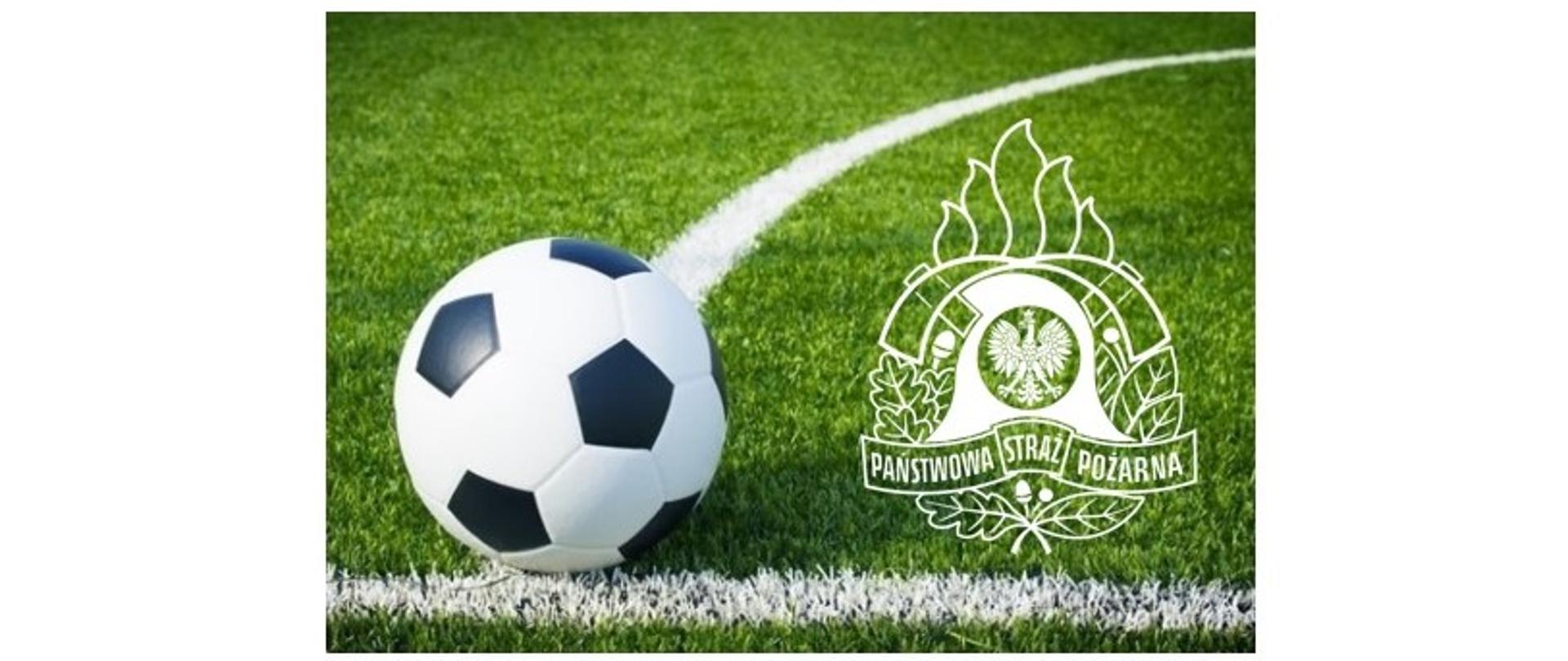 Zdjęcie przedstawia z prawej strony logo Państwowej Straży Pożarnej, a z lewej piłkę do gry w piłkę nożną z czarno-białymi łatami, która znajduje się na części trawiastego boiska piłkarskiego oznaczonego liniami. Obraz nawiązuje do IV Turniej Piłki Nożnej o Puchar Warmińsko–Mazurskiego Komendanta Wojewódzkiego Państwowej Straży Pożarnej