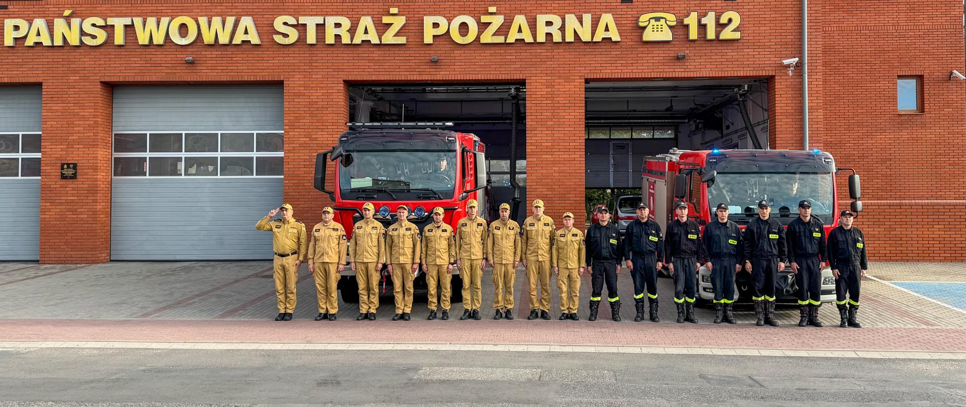 zdjęcie strażaków przed budynkiem komendy oraz samochodami 