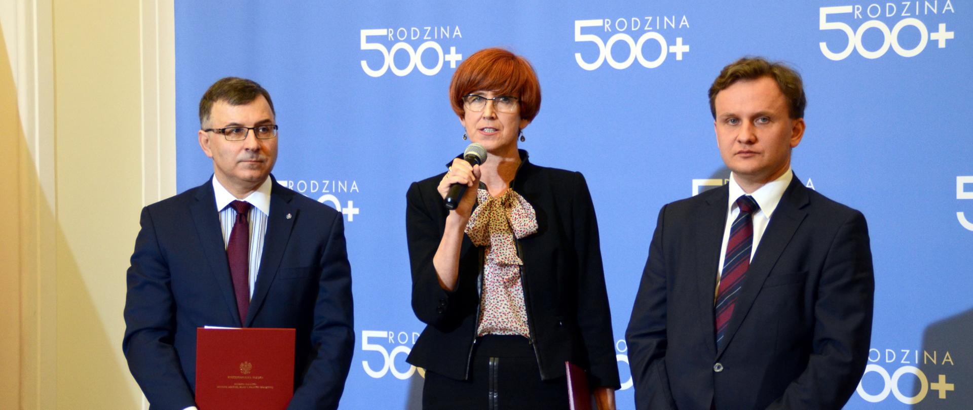 Podpisano porozumienie pomiędzy PKO Bankiem Polskim a Ministerstwem Rodziny, Pracy i Polityki Społecznej dotyczące składania wniosków o świadczenie wychowawcze poprzez bankowość elektroniczną. Na zdjęciu minister rodziny, Elżbieta Rafalska, wiceminister rodziny Bartosz Marczuk oraz Prezes Zarządu PKO Bank Polski, Zbigniew Jagiełło. 