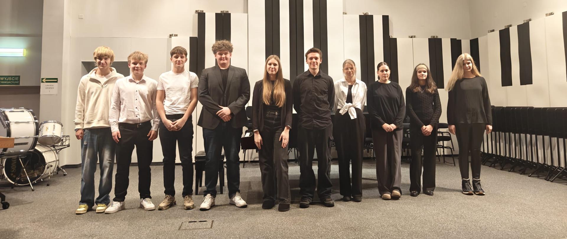 Wszyscy wykonawcy stoją na scenie.