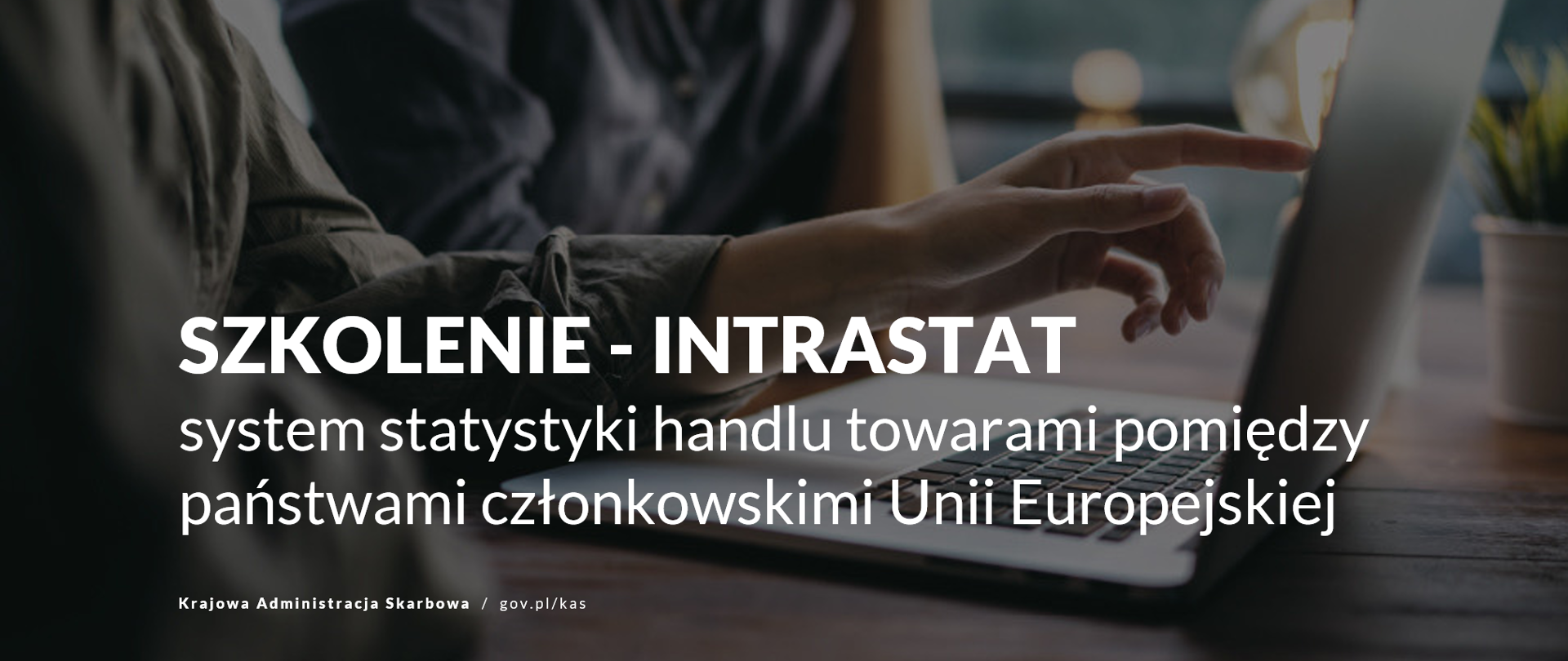 Dwie osoby pracujące przy laptopie – jedna wskazuje palcem na ekran komputera. Na grafice widoczny napis: „Szkolenie – INTRASTAT. System statystyki handlu towarami pomiędzy państwami członkowskimi Unii Europejskiej” oraz logo Krajowej Administracji Skarbowej.