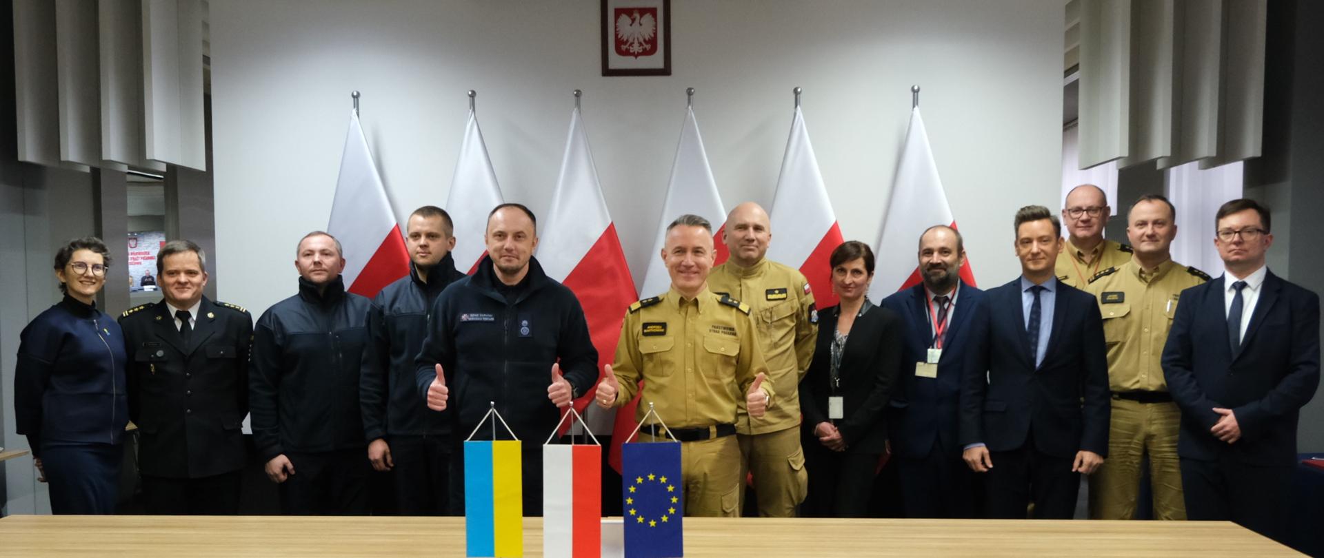 Na zdjęciu widać jak komendant główny PSP wraz z Sergiejem Krukiem oraz wszystkimi zebranymi przedstawicielami pozują do wspólnego zdjęcia. 