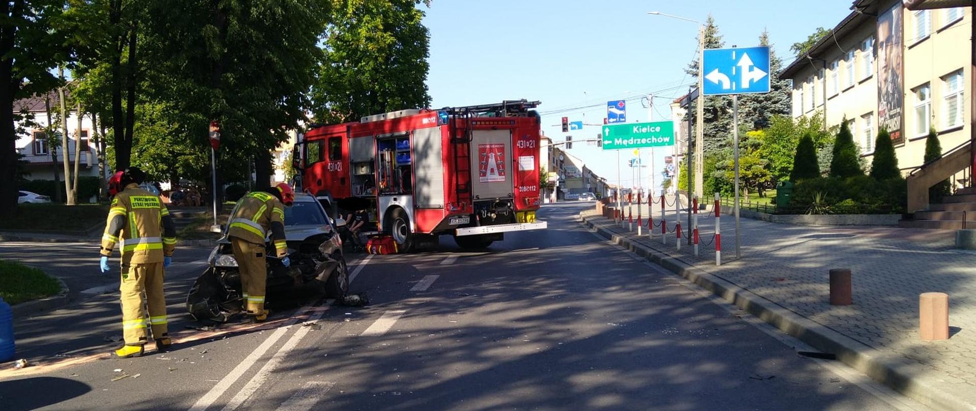 Na zdjęciu widać jeden z pojazdów biorących udział w zdarzeniu, strażaków PSP, oraz pojazd ratowniczo-gaśniczy.