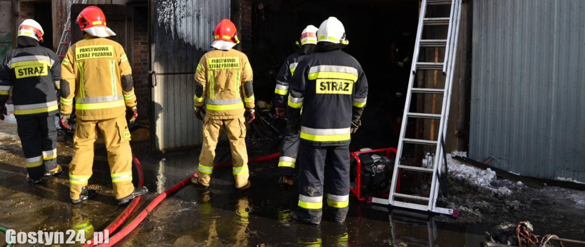 Strażacy gaszą pożar garażu.