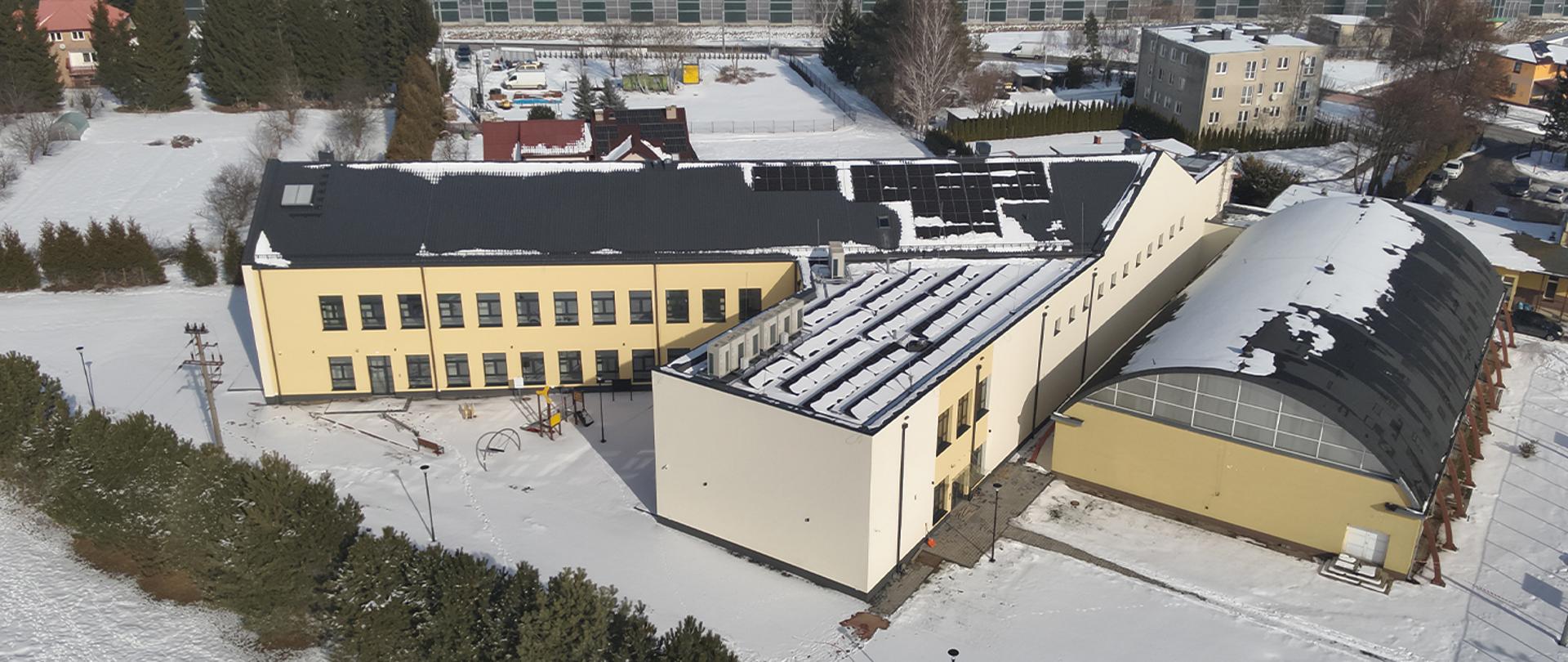 Rozbudowany budynek szkoły w Bystrzejowicach Pierwszych z nową częścią przeznaczoną na żłobek i przedszkole, widok z lotu ptaka.