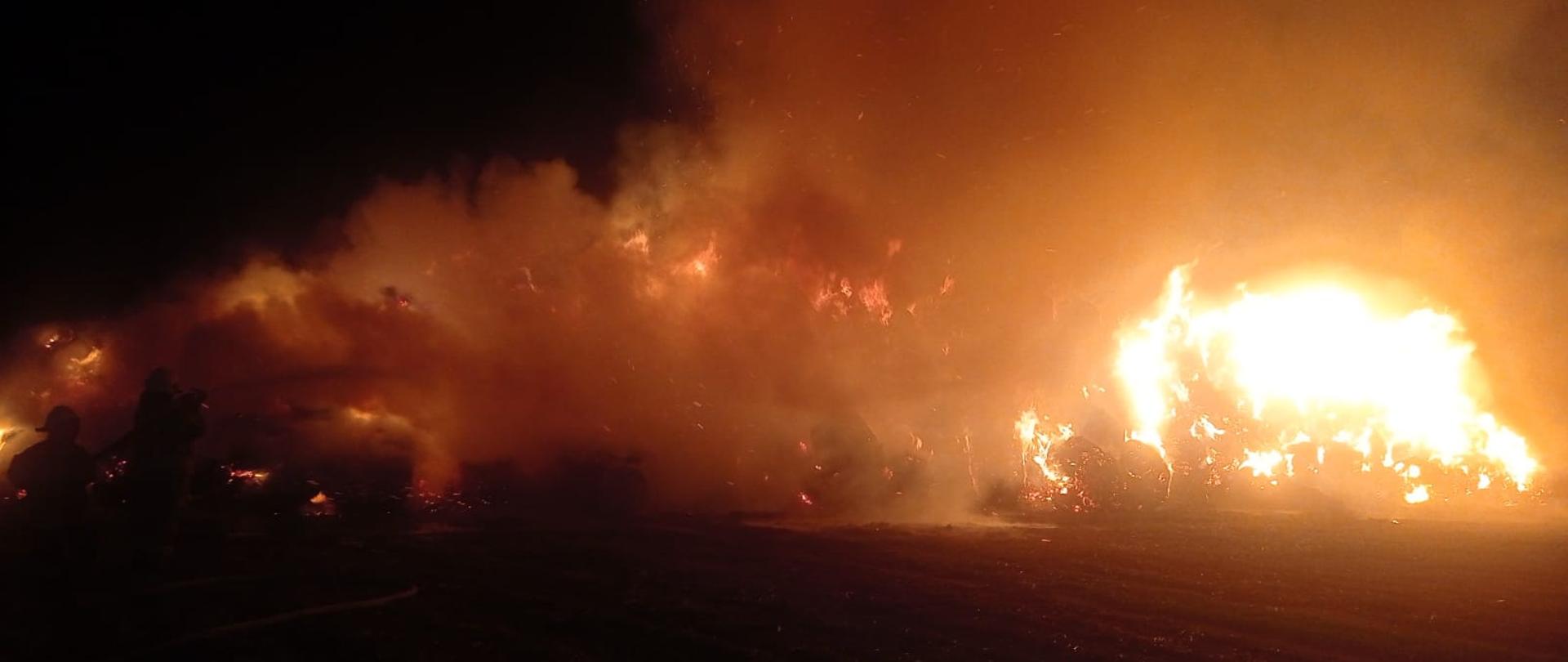 Zdjęcie przedstawia palącą się stertę słomy