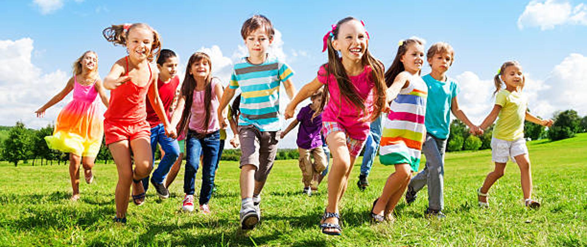 Many different kids, boys and girls running in the park on sunny summer day in casual clothes
