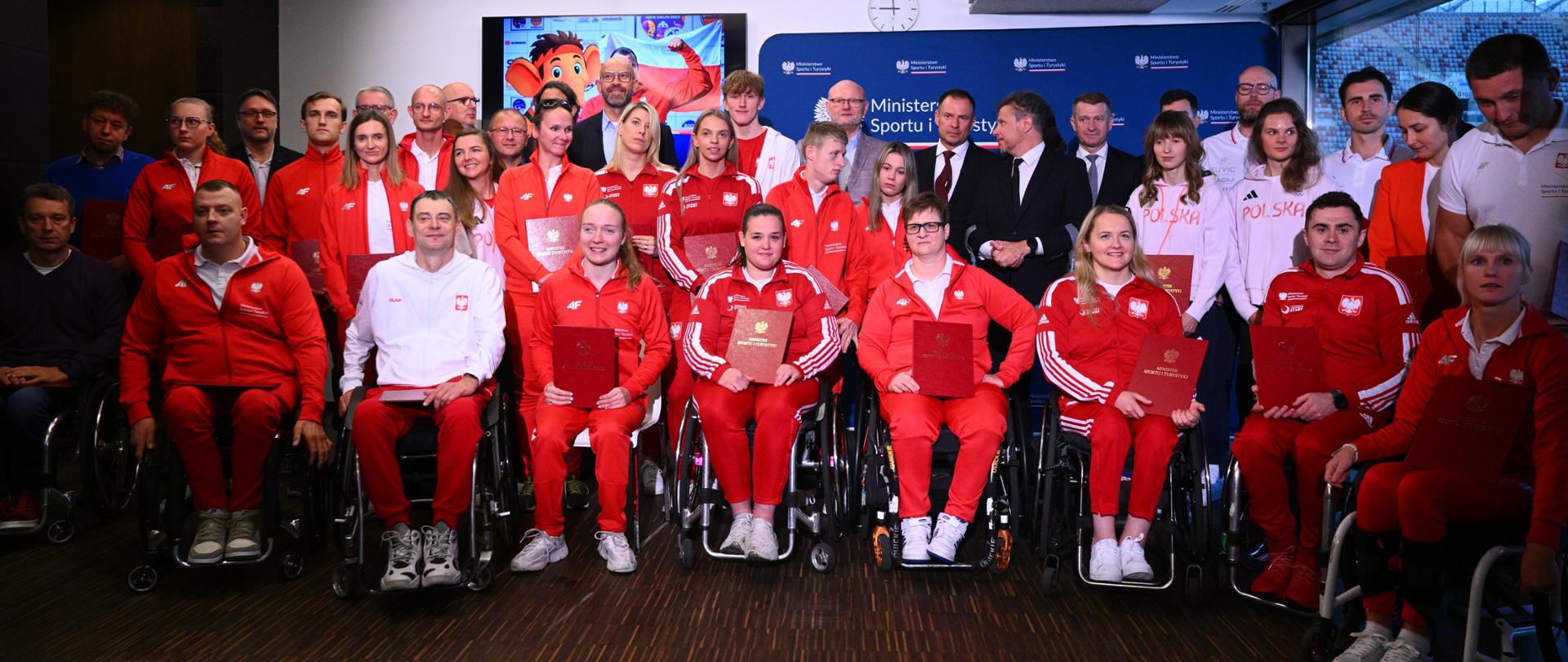 Zbiorowe zdjęcie ministra sportu i turystyki Jakuba Rutnickiego, sekretarzy stanu w Ministerstwie Sportu i Turystyki z medalistami paralekkoatletycznych mistrzostw świata w New Delhi, mistrzostw świata w parakolarstwie w Ronse, mistrzostw świata w szermierce na wózkach w Iksan, mistrzostw świata w parapływaniu w Singapurze, sztabami trenerskimi i przedstawicielami Polskiego Komitetu Paralimpijskiego.