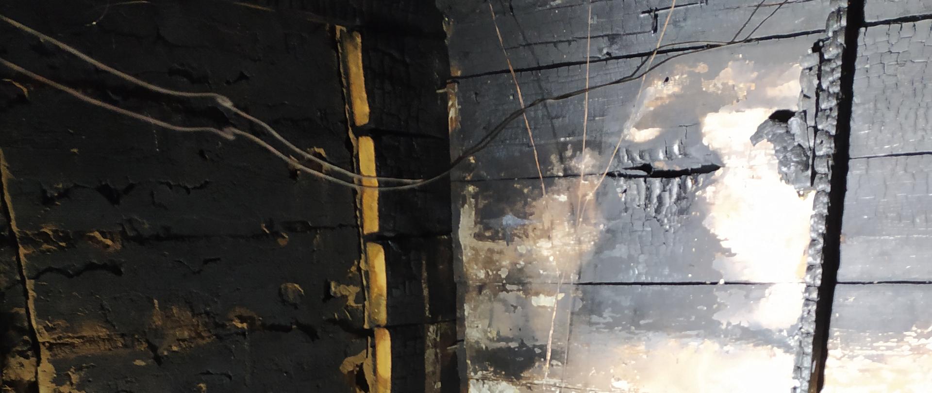 Zdjęcie przedstawia wnętrze obiektu objętego pożarem.