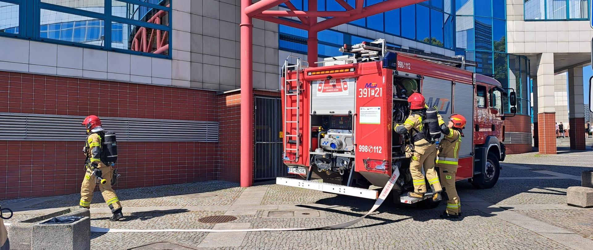 Strażacy wyciągają węże