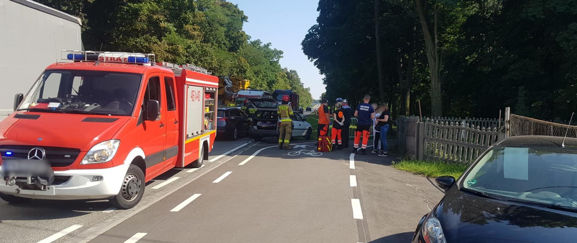 widoczne miejsce zdarzenia uszkodzone pojazdu oraz służby działające na miejscu.