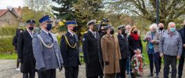 Przedstawiciele służb mundurowych składają wieniec.