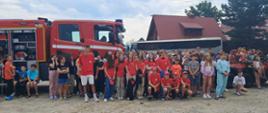 Zdjęcie grupowe uczestników obozu na tle samochodu gaśniczego.