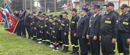 Strażacy stoją podczas uroczystości.