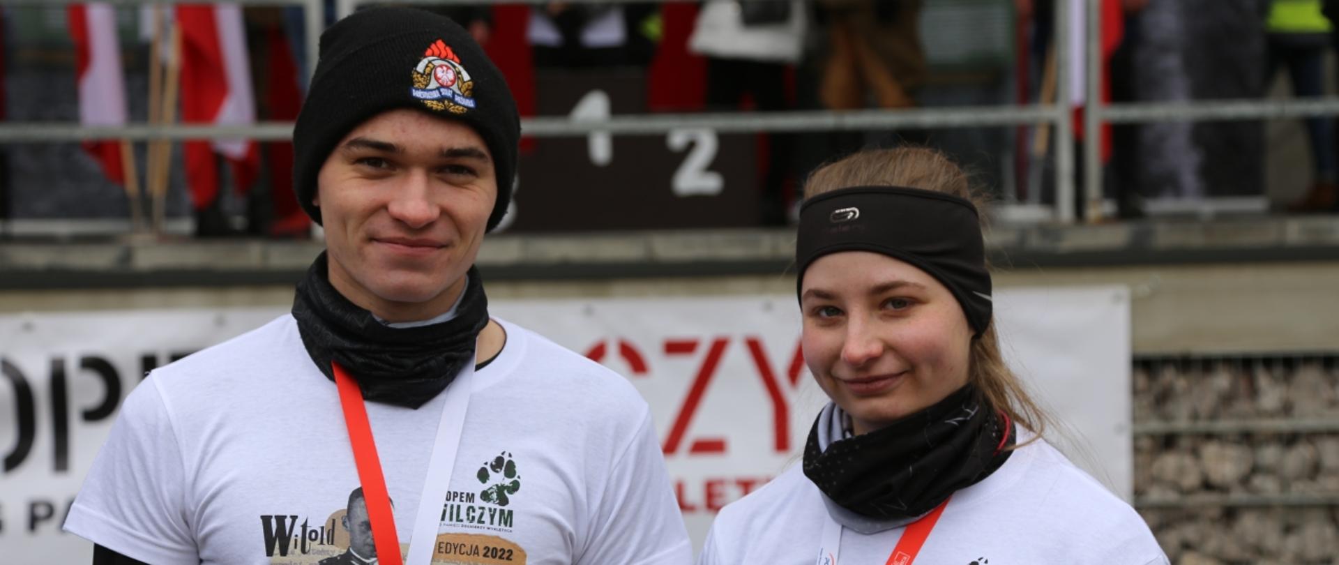 Kadetka oraz kadet Centralnej Szkoły PSP z okolicznościowymi medalami