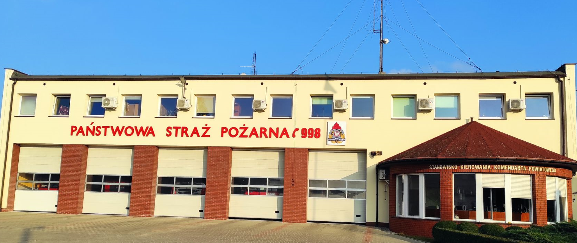wyremontowany budynek straży pożarnej, żółta elewacja, napis panństwowa straż pożarna, logo 