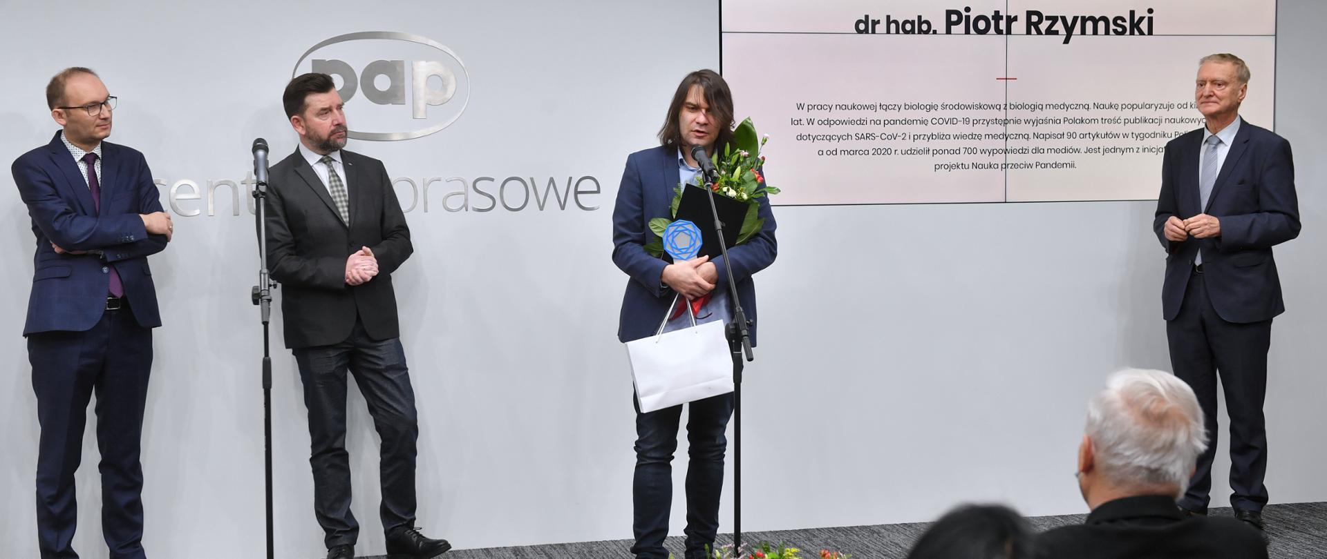 Laureat przemawia po otrzymaniu nagrody. w reku trzyma statuetkę i kwiaty