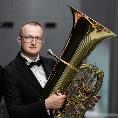 Mężczyzna trzyma tubę.