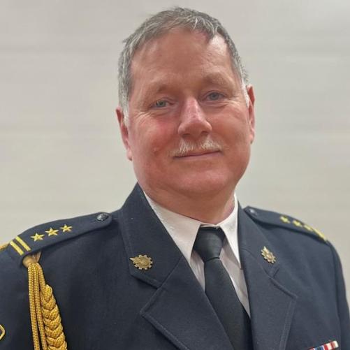 Funkcjonariusz PSP w mudnurze galowym na tle białej ściany