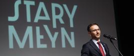 wiceminister Waldemar Buda mówi do mikrofonu, za nim napis Stary Młyn