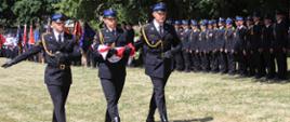 Poczet flagowy w trakcie maszerowania. W tle widoczne poddziały PSP oraz poczty sztandarowe OSP