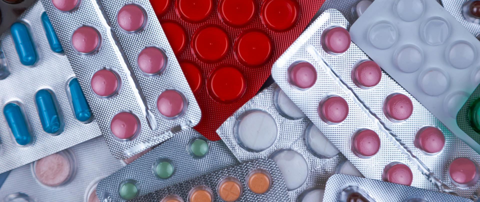 Obraz zawierający blistry z tabletkami w różnych kolorach.