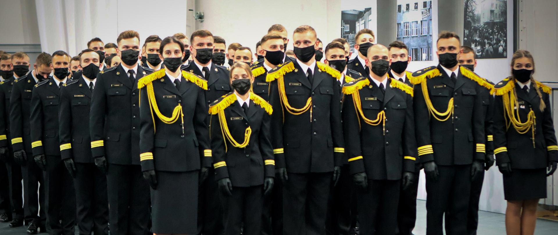 Na zdjęciu widać pododdział podchorążych Szkoły Głównej Służby Pożarniczej w umundurowaniu wyjściowym, po cztery osoby w ośmiu szeregach.