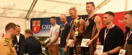 Mistrzostwa Polski Strażaków Państwowej Straży Pożarnej w Siatkówce Plażowej. Zdjęcie przedstawia strażaków PSP podczas wręczenie nagród. 