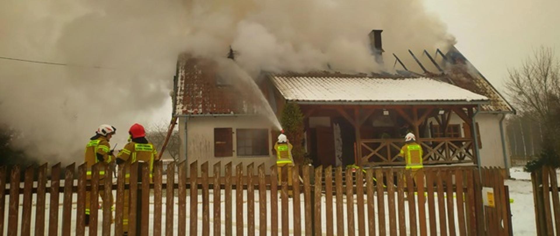Strażacy gaszą pożar domu w miejscowości Kamienna Struga