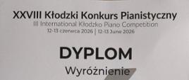 
Dyplom wyróżnienia dla Marii Narowskiej w XXVIII Kłodzkim Konkursie Pianistycznym (12–13 czerwca 2026), przyznany przez jury konkursu. Na dyplomie widnieje grafika fortepianu oraz podpisy członków jury.