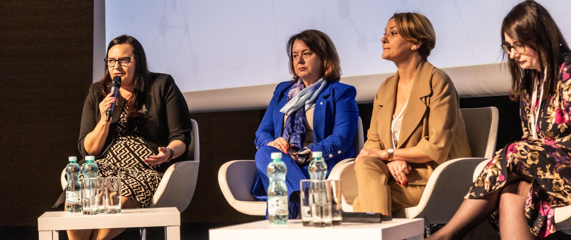 Cztery kobiety siedzą w fotelach przy stolikach. Pierwsza od lewej wiceminister Małgorzata Jarosińska-Jedynak z mikrofonem.