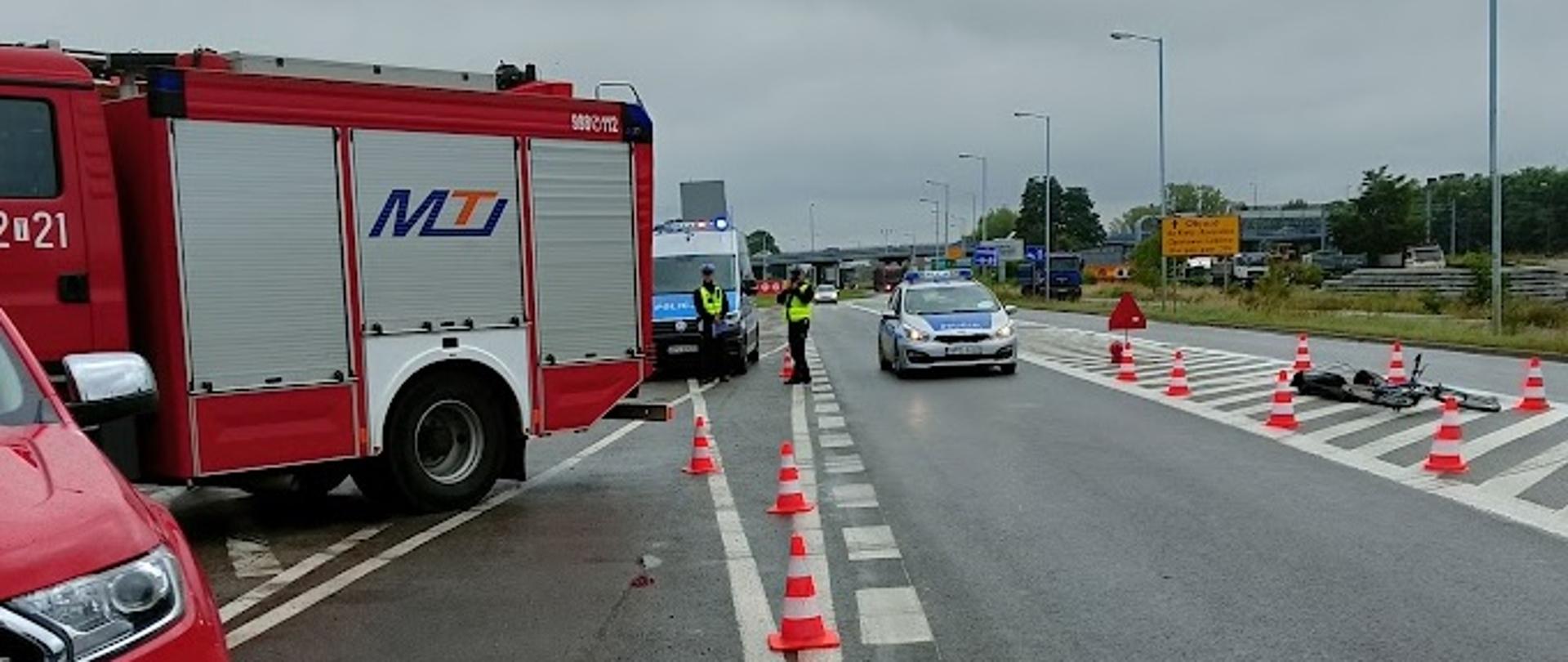 Przy ul. Zagłoby w Ostrowcu Św. zaparkowane wzdłuż samochody gaśnicze oraz patrol policji zatrzymujący kierowców 