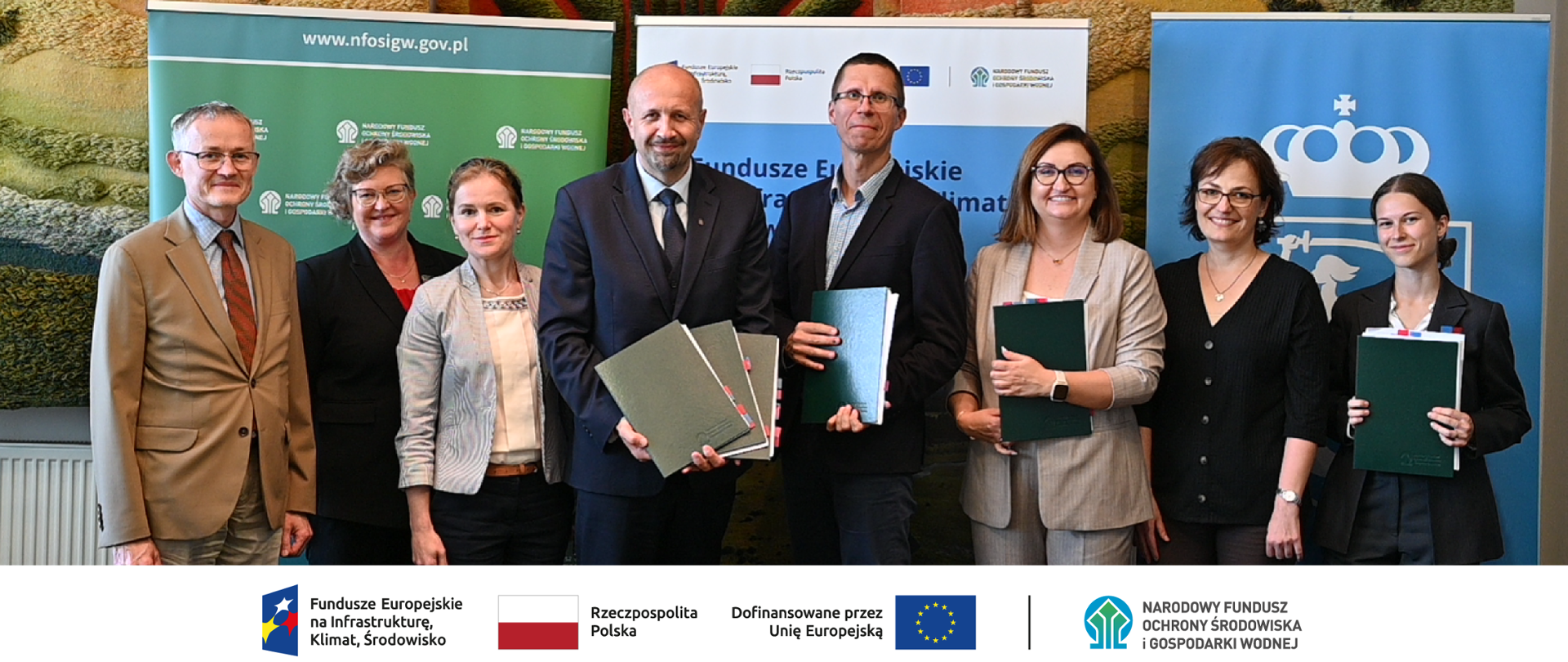 Na zdjęciu od lewej: Leszek Jóskowiak, kierownik Wydziału Ochrony Przyrody NFOŚiGW, Barbara Maksimowska zastępca kierownika Wydziału Ochrony Przyrody, Anna Małek-Zielińska koordynator WOP, Robert Gajda zastępca prezesa zarządu NFOŚiGW ,Maciej Fijałkowski - sekretarz m.st. Warszawy, zastępca dyrektora Biura Funduszy Europejskich i Polityki Rozwoju Urzędu m.st. Warszawy - Urszula Świerżewska-Chrzan , Renata Nastula, Natalia Nowakowska.Na dole ciąg znaków, logotypy od lewej: FEnIKŚ, flaga Rzeczypospolita Polska, flaga UE Dofinansowane przez UE, NFOŚiGW.