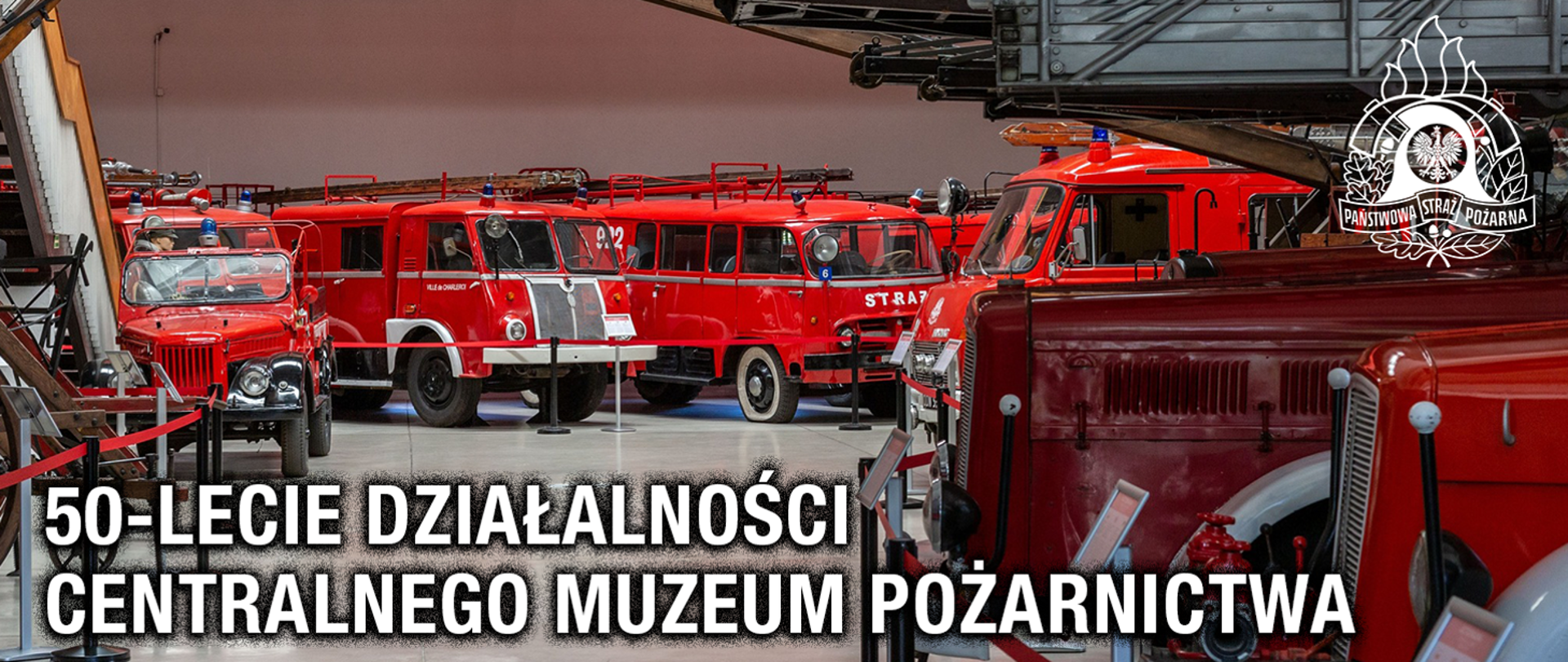 Grafika przedstawia wnętrze muzeum z wieloma zabytkowymi wozami strażackimi, które stoją obok siebie. Wszystkie pojazdy są czerwone, mają charakterystyczne syreny i oznaczenia „STRAŻ”. Są to starsze modele, niektóre wyglądają jak furgonetki, inne jak ciężarówki, a także znajduje się tam odkryty samochód terenowy.
Na dole obrazu widnieje duży biały napis: „50-lecie działalności Centralnego Muzeum Pożarnictwa”.W prawym górnym rogu znajduje się logo Państwowej Straży Pożarnej – w środku jest orzeł biały, otoczony płomieniami i wieńcem.