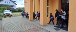 Na zdjęciu widać uczniów wychodzących z budynku szkoły.
