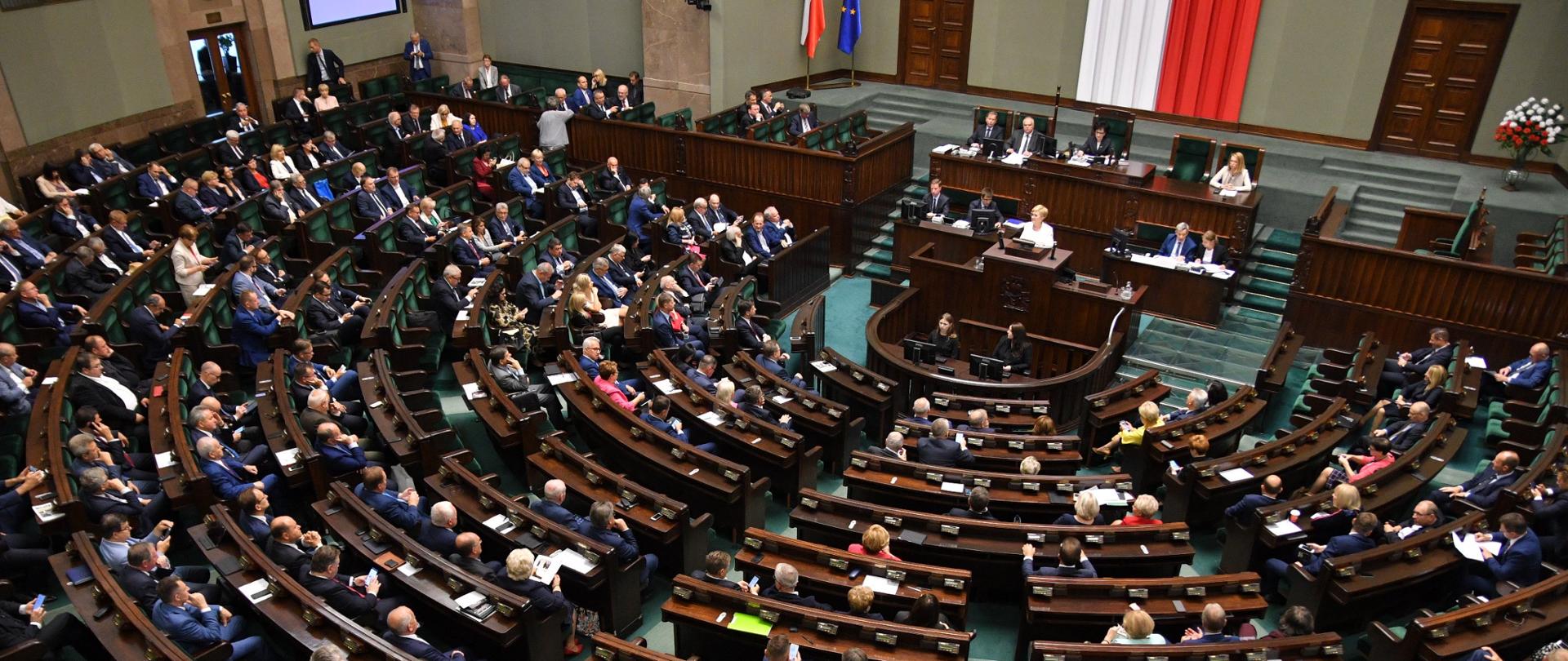 Widok z góry na pełną salę posiedzeń w Sejmie.
