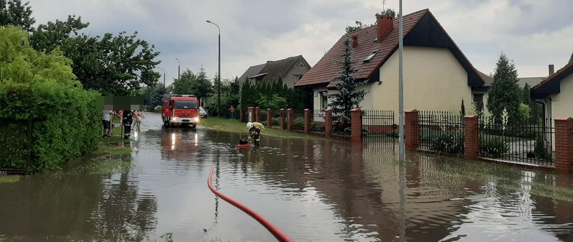Na zdjęciu widać strażaka działającego podczas podtopień 