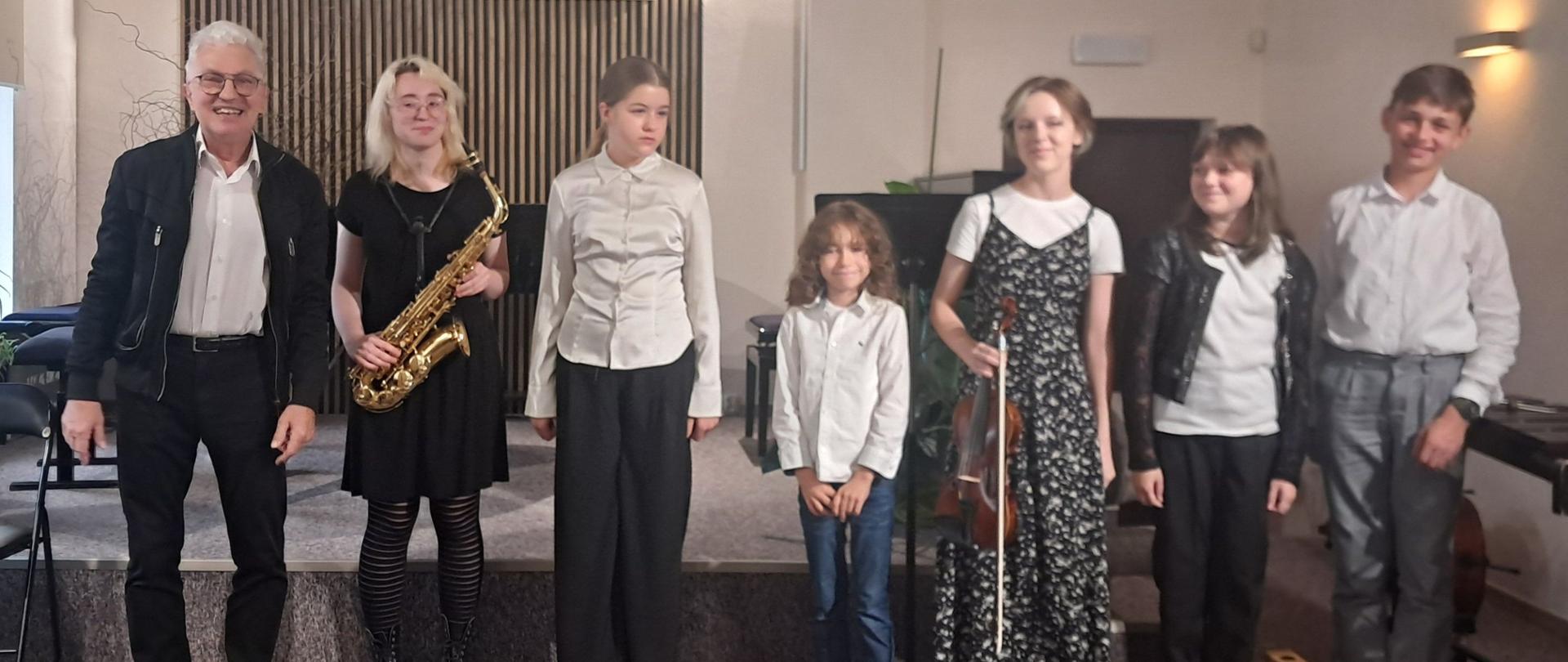 Uczestnicy koncertu stoją w szeregu na scenie