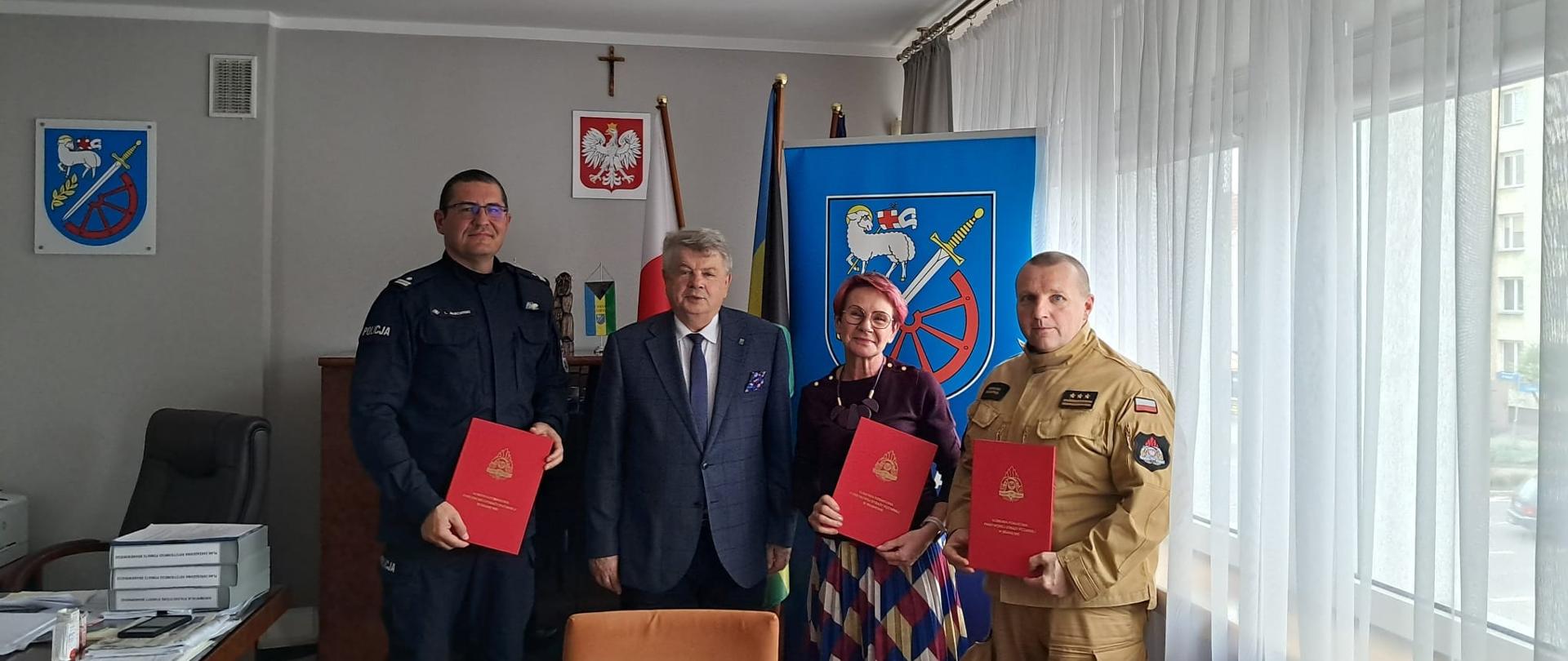 Gabinet starosty braniewskiego. Od prawej stoją komendant Powiatowy PSP, Pani inspektor nadzoru budowlanego, starosta braniewski i komendant policji z Braniewa