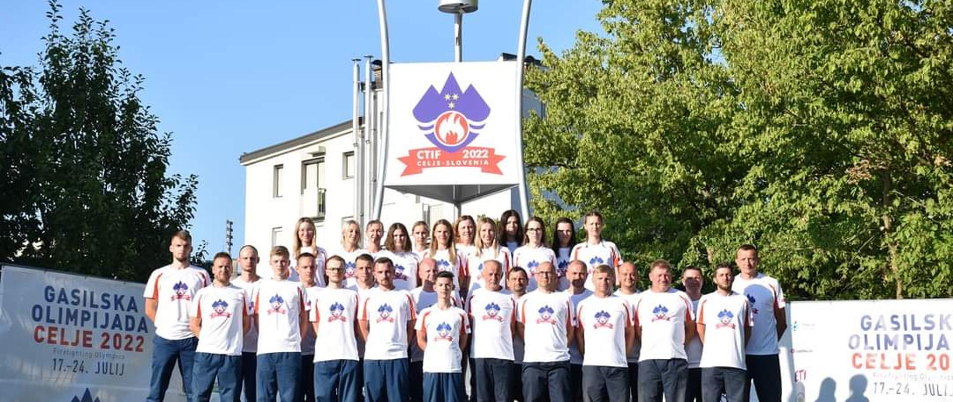 Na zdjęciu znajdują się strażacy ustawieni przed zniczem na olimpiadzie pożarniczej