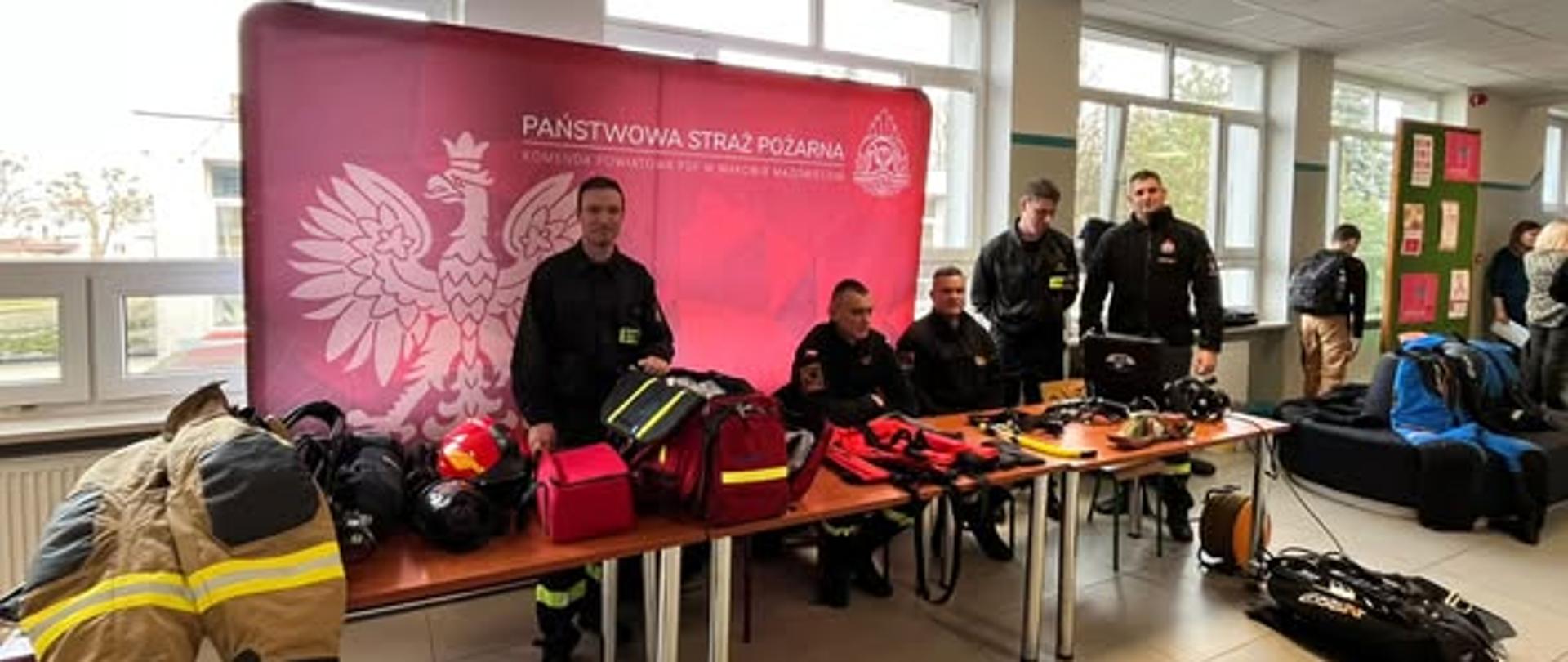 Stoisko promujące Straż Pożarną przy którym znajduje się pięciu funkcjonariuszy KP PSP. 