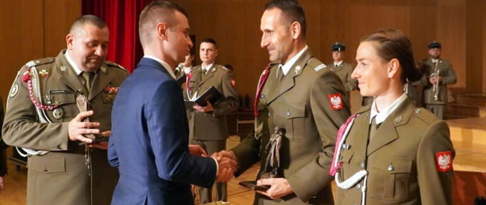 Wicewojewoda podkarpacki Radosław Wiatr podaje rękę żołnierzowi 21 Brygady Strzelców Podhalańskich podczas uroczystości w Filharmonii Podkarpackiej