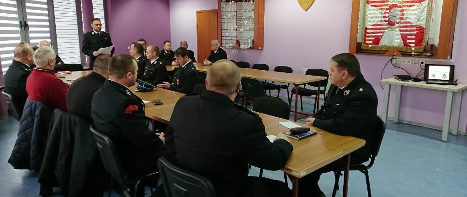 Sala Nard KP PSP we Włoszczowie, członkowie prezydium zarządu wraz z komendantem powiatowym PSP siedzą przy stołach ustawionych w podkowę