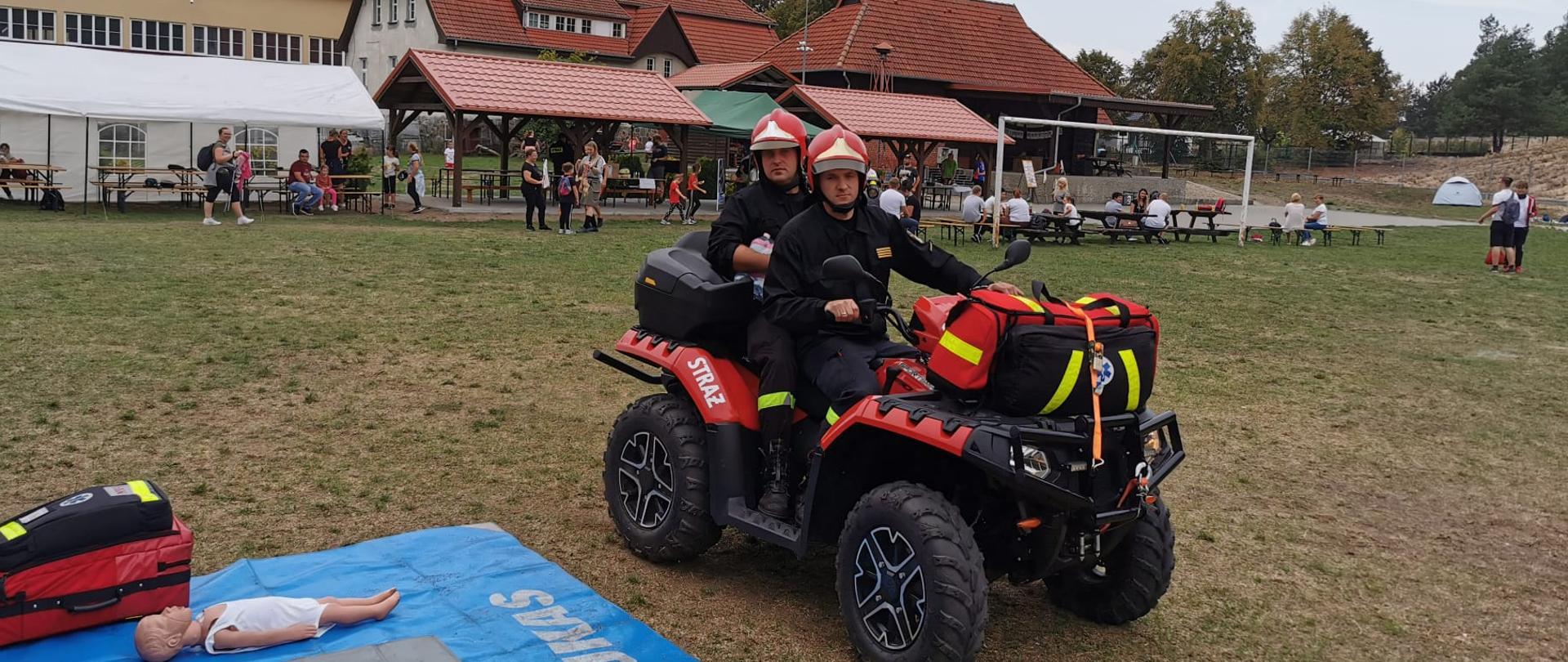 Strażacy siedzą na quadzie.