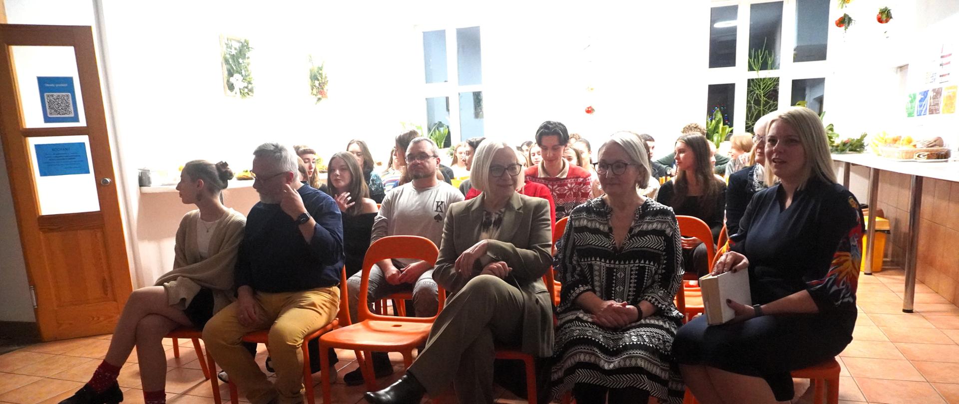 Pani Dyrektor, społeczność bursy oraz gość, tata Róży, oczekują na rozpoczęcie uroczystości. 