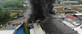 Zdjęcie wykonane z drona. Przedstawia budynki firmy objęte pożarem. 